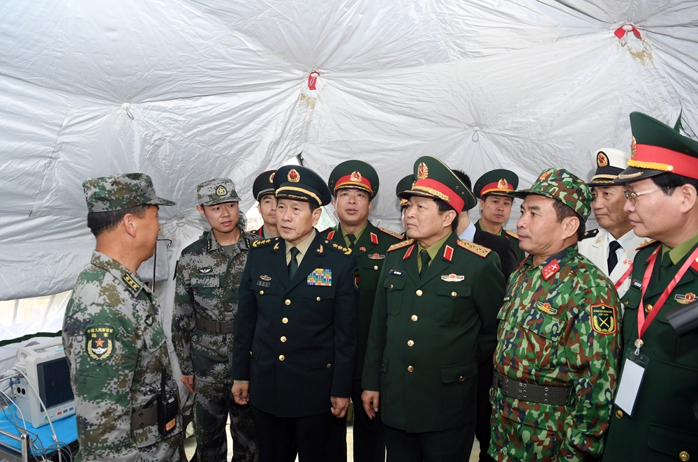 Bộ trưởng Ngô Xuân Lịch và Bộ trưởng Ngụy Phượng Hòa tham quan mô hình khu y tế dã chiến trong cuộc diễn tập của quân đội hai nước.